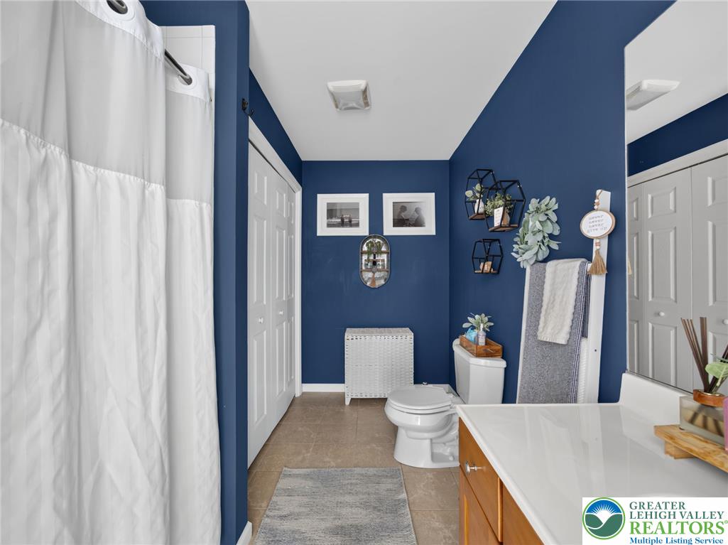 4148 Ross Road Bethlehem, PA 18020 - Photo 61 of 67 A vibrant blue wall bathroom with a white shower curtain and a white sink, offering a refreshed space.