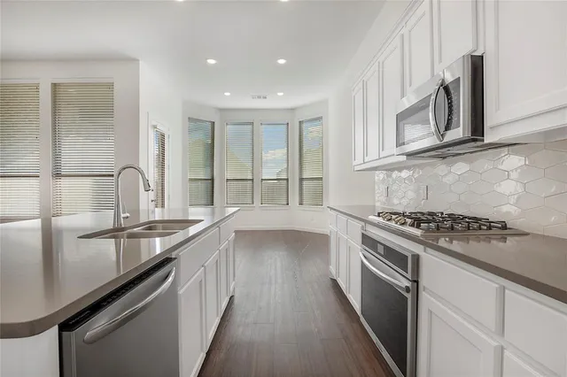 a kitchen with stainless steel appliances granite countertop a sink stove and cabinets