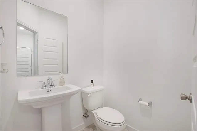 a bathroom with a sink a toilet and a mirror