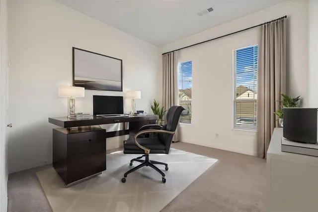 a view of a workspace with furniture and a window