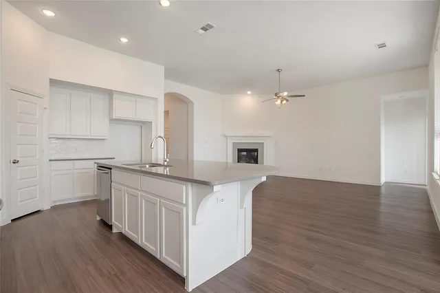 a kitchen with white cabinets and sink