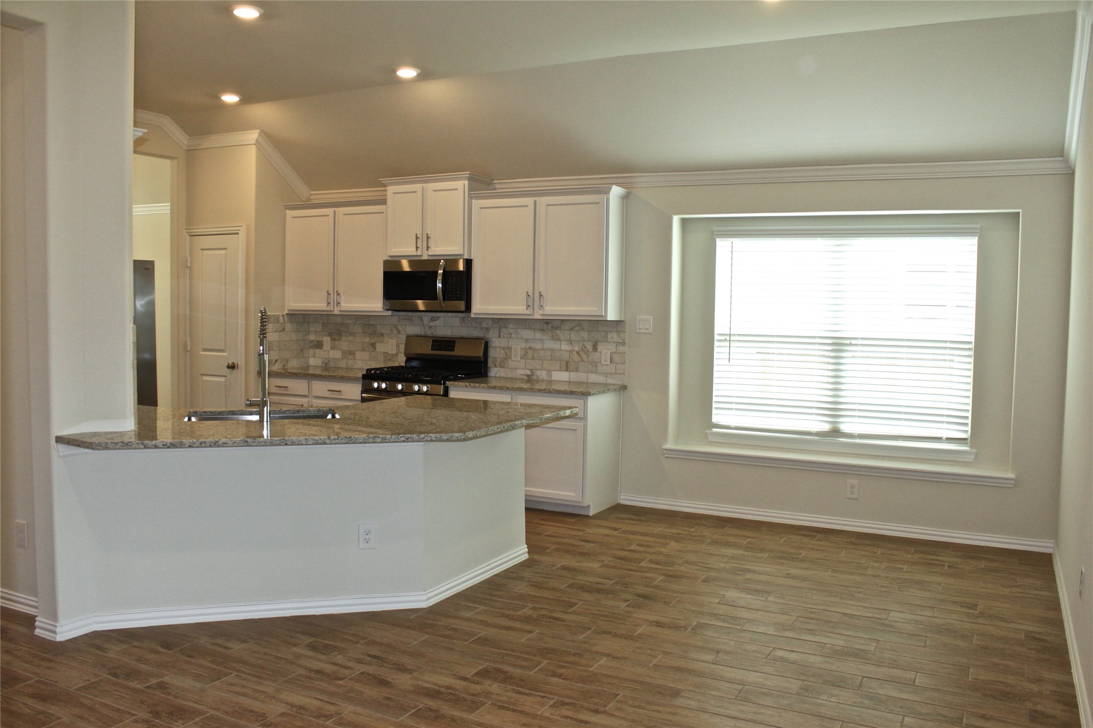 4408 Mimic Drive Spring, TX 77386 - Photo 3 of 27 a kitchen with stainless steel appliances granite countertop a stove a sink and a microwave