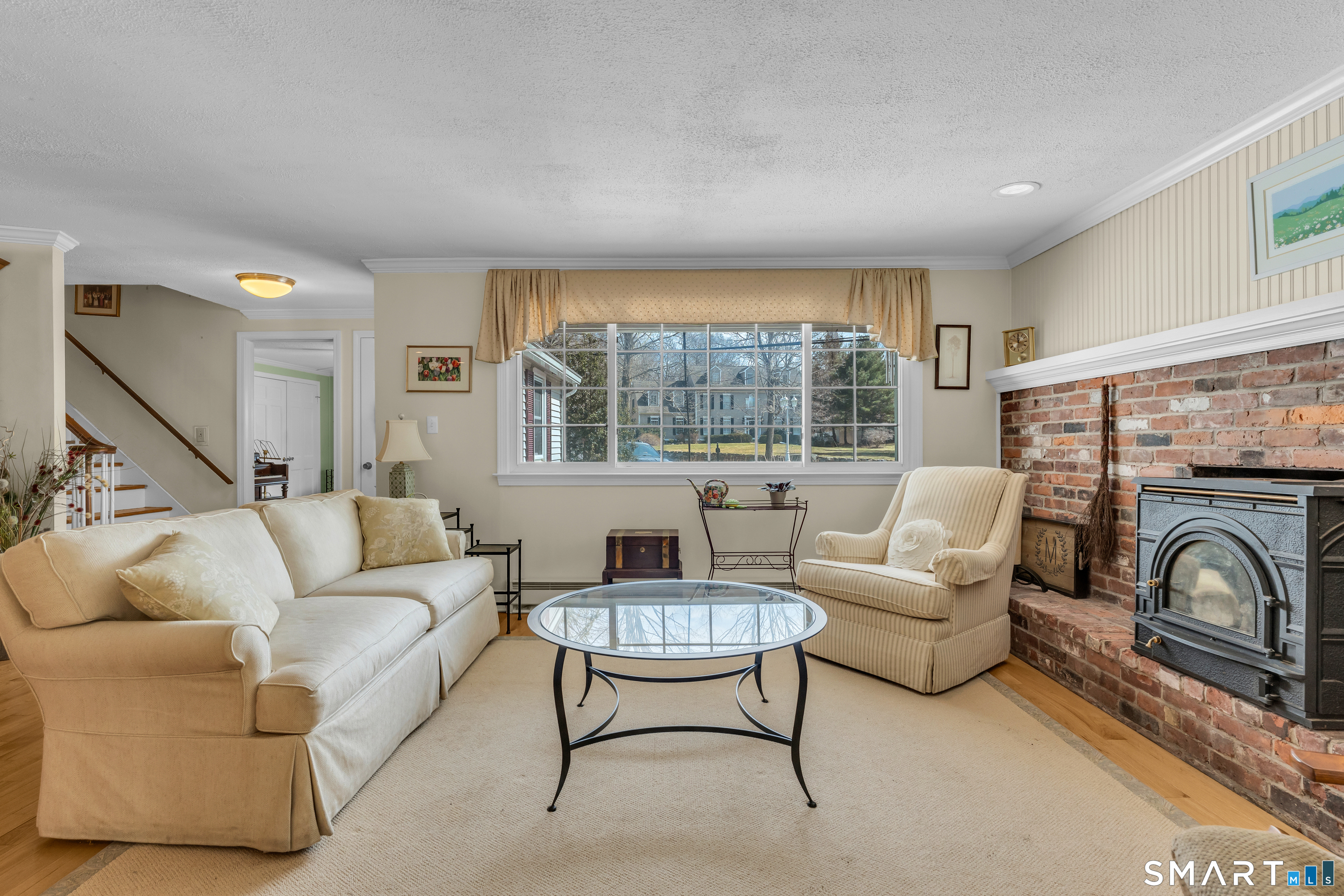 110 Nut Plains Road Guilford, CT 06437 - Photo 5 of 40 Timeless brick, warm wood floors, and a picture window framing the neighborhood beyond. Classic New England living at its best.