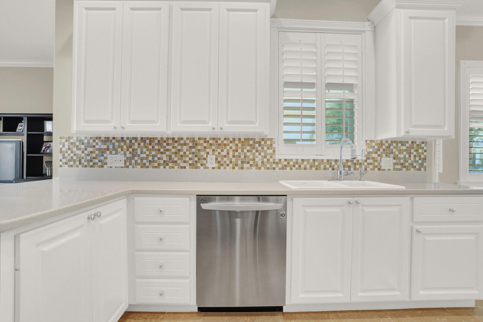 2688 East Community Drive Jupiter, FL 33458 - Photo 18 of 50 a kitchen with granite countertop white cabinets and sink