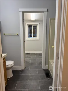 a bedroom with wooden floor closet and windows