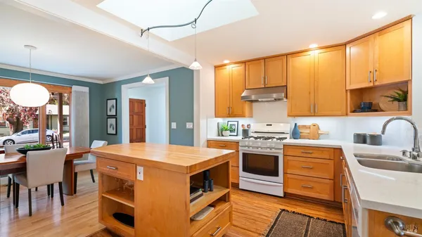 a large kitchen with stainless steel appliances a sink dishwasher stove refrigerator and cabinets