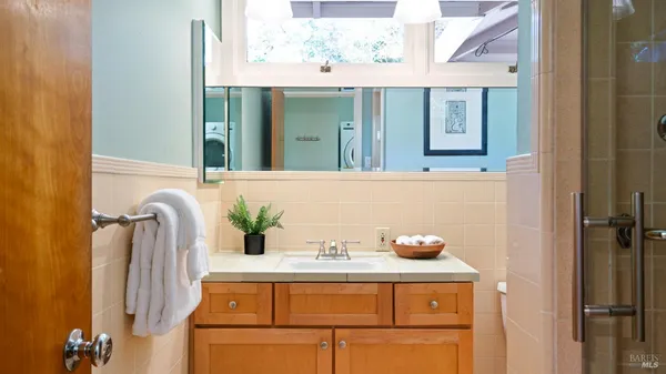 a bathroom with a sink a window and shower