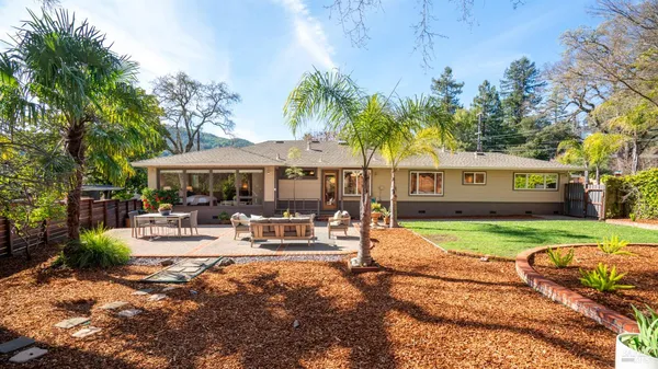 a view of a house with backyard and sitting area