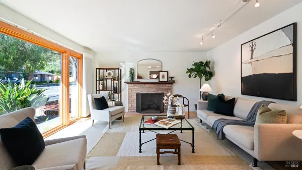 a living room with furniture a fireplace and a large window