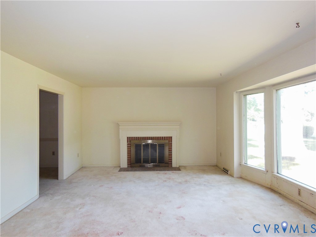 8218 Overbury Road Richmond, VA 23227 - Photo 5 of 37 an empty room with a fireplace and windows