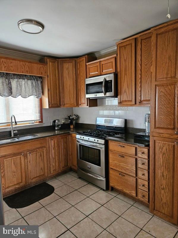 3911 4th Street Baltimore, MD 21225 - Photo 6 of 18 a kitchen with stainless steel appliances granite countertop a stove a sink and a microwave