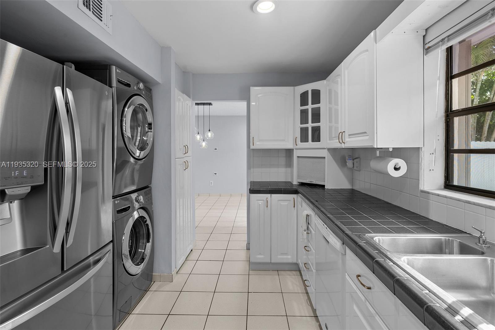10922 Southwest 25th Street Miami, FL 33165 - Photo 11 of 33 a kitchen with stainless steel appliances granite countertop a sink and a refrigerator