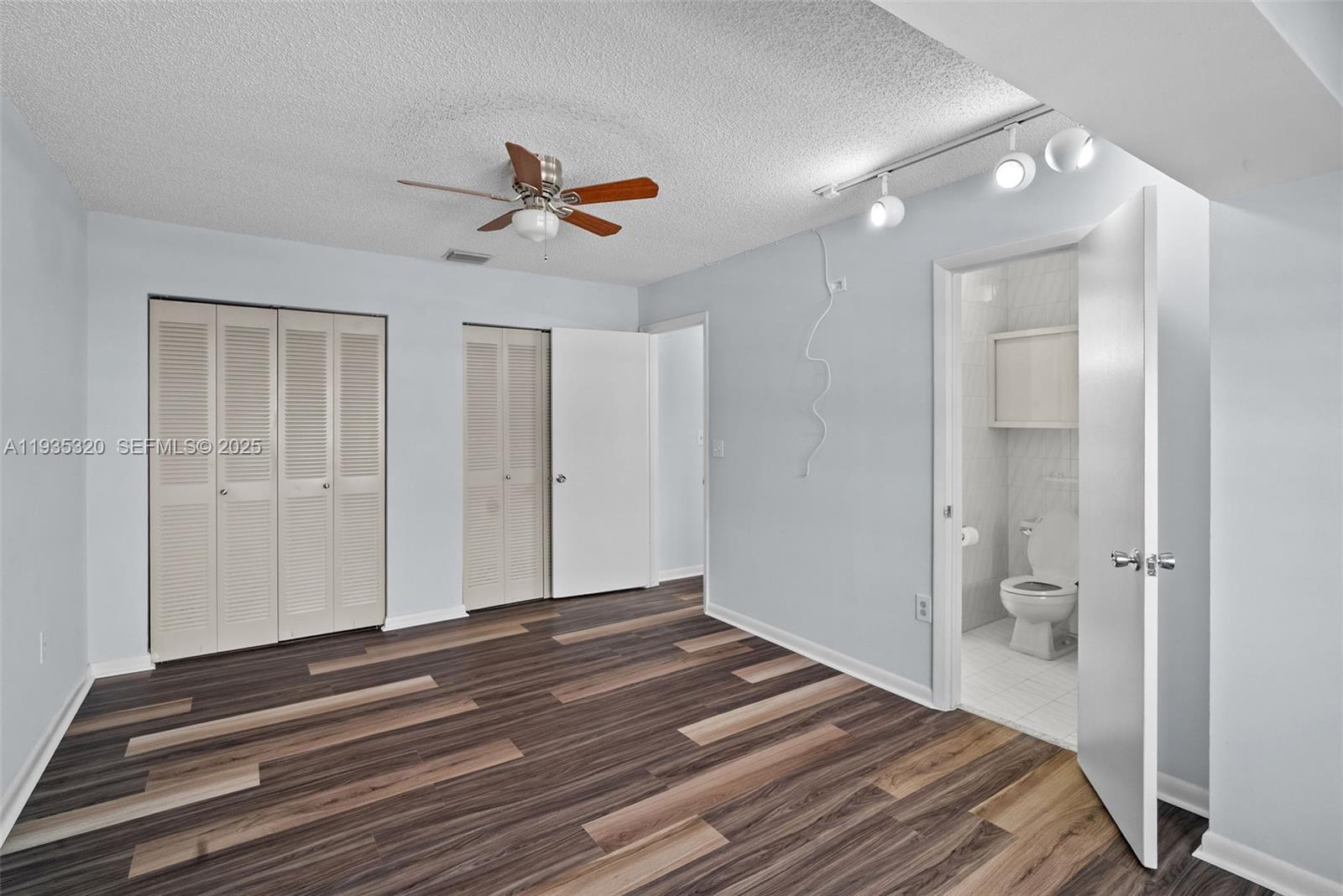 10922 Southwest 25th Street Miami, FL 33165 - Photo 25 of 33 a bedroom with a bed and a chandelier fan