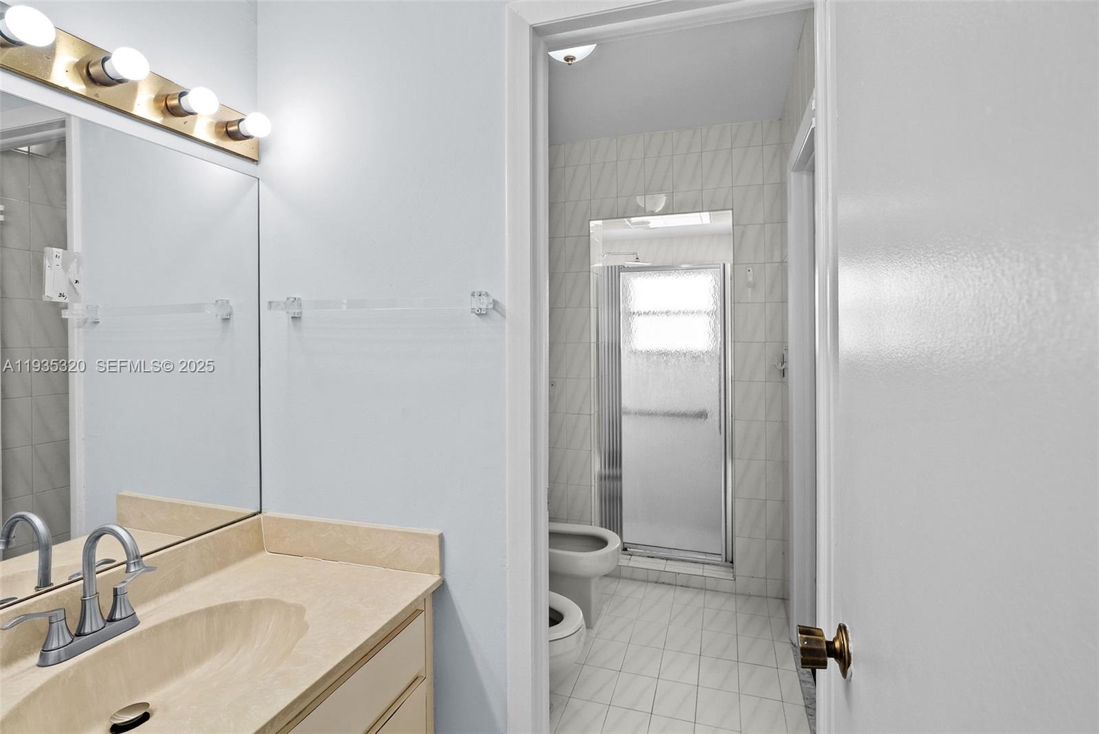 10922 Southwest 25th Street Miami, FL 33165 - Photo 26 of 33 a bathroom with a sink and a mirror