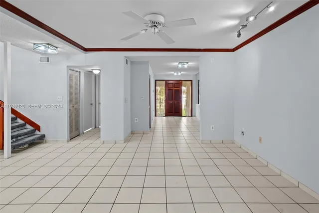 a view of an empty room with window and chandelier