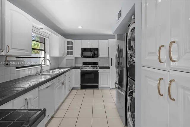 a kitchen with granite countertop a stove sink and cabinets