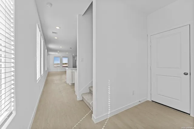 a view of a hallway with a livingroom and a bathroom with sink