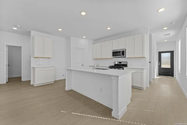 a kitchen with white cabinets and stainless steel appliances