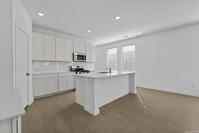 a kitchen with white cabinets and white appliances
