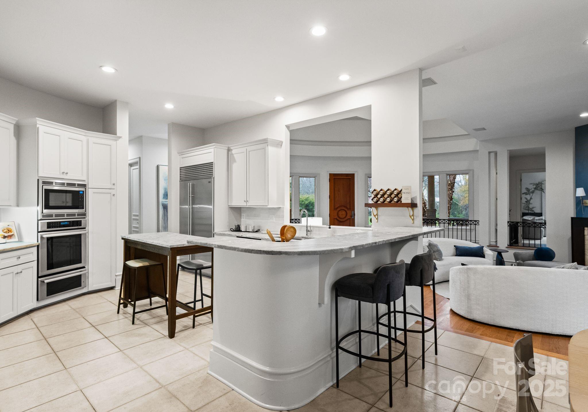8813 Covey Rise Court Charlotte, NC 28226 - Photo 14 of 47 a kitchen with a dining table chairs cabinets and stainless steel appliances