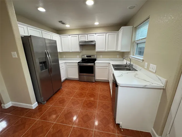 a kitchen with stainless steel appliances granite countertop a stove a refrigerator a sink a microwave and island