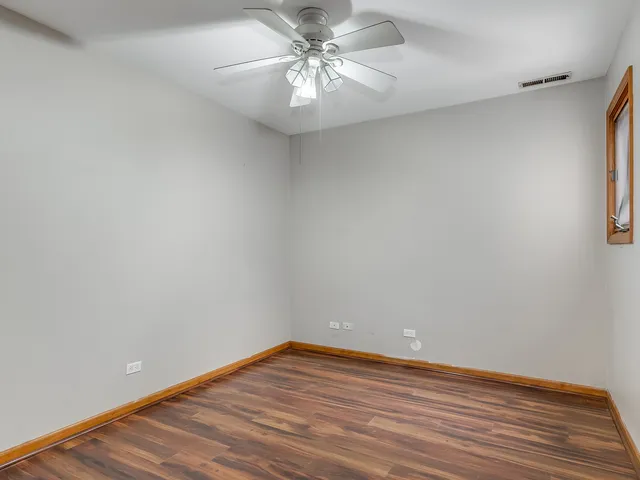 a view of a room with wooden floor and a ceiling fan