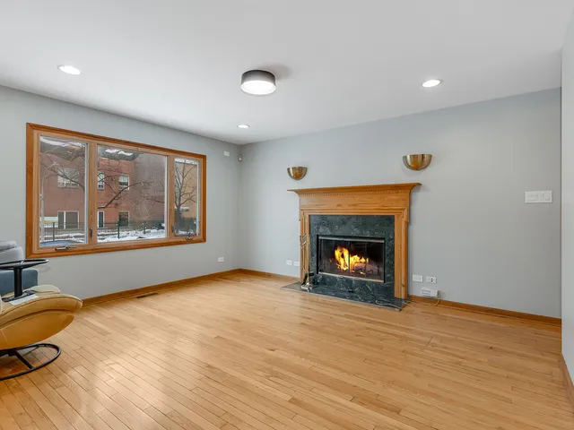 a view of an empty room with a window and fire place