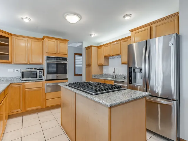 a kitchen with stainless steel appliances a stove a refrigerator a sink a stove top oven and a refrigerator