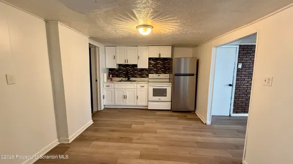 a view of a kitchen with a sink a refrigerator and window