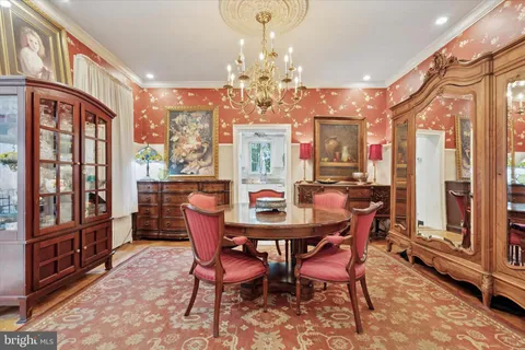 a dining room with furniture a chandelier and wooden floor