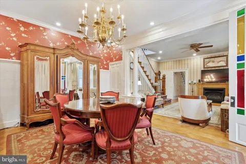a view of a dining room with furniture a chandelier and wooden floor