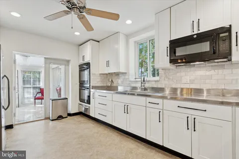 a kitchen with stainless steel appliances kitchen island granite countertop a refrigerator and a stove top oven