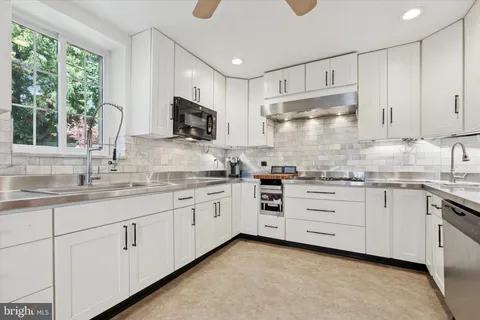 a backyard with table and chairs and potted plants