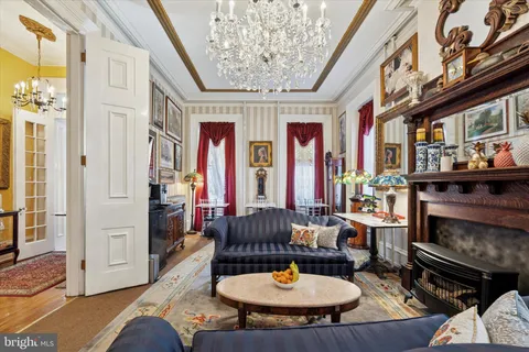 a living room with furniture a fireplace and a chandelier