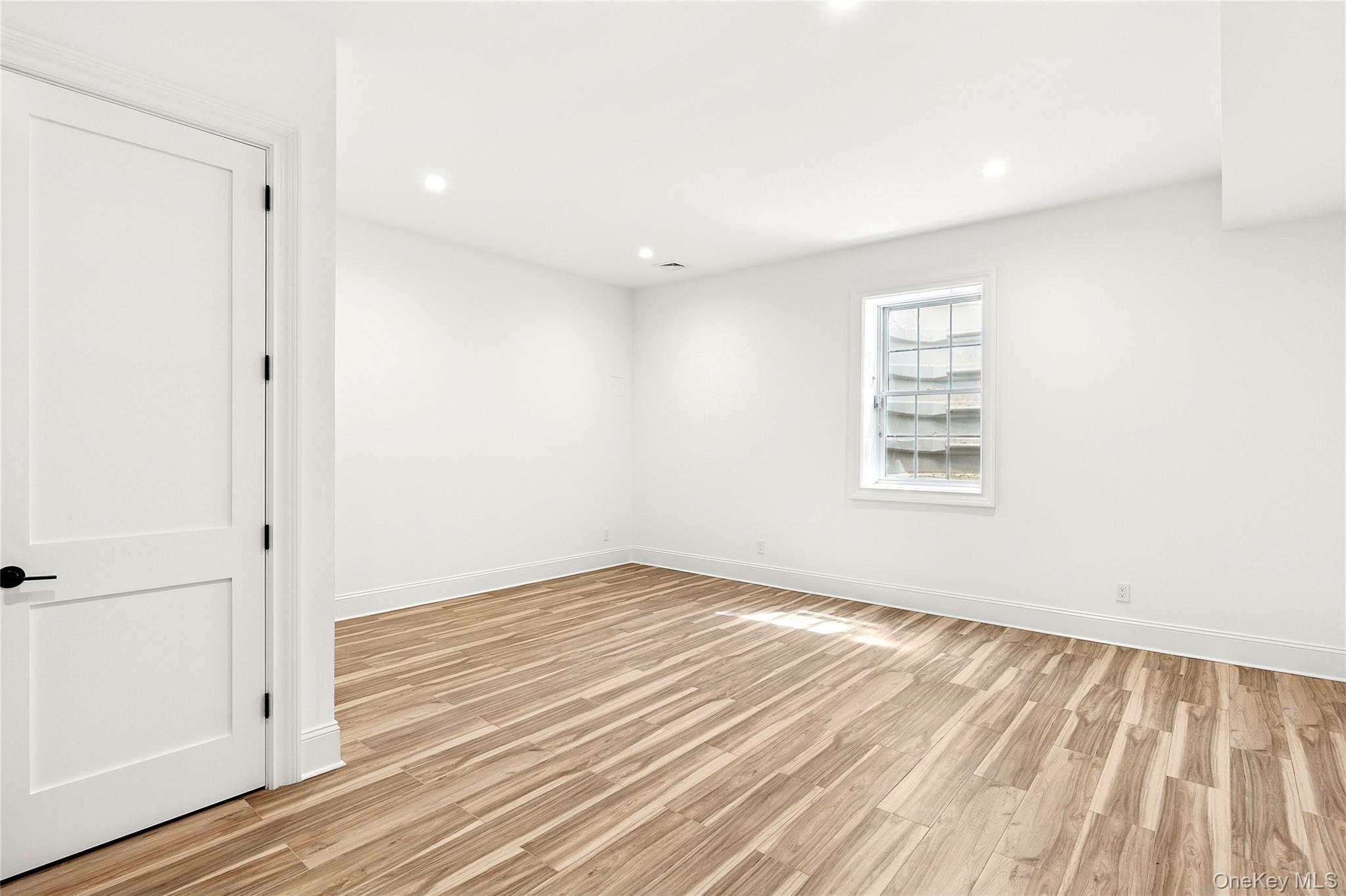 80 Deer Run Southold, NY 11971 - Photo 23 of 29 an empty room with wooden floor and windows