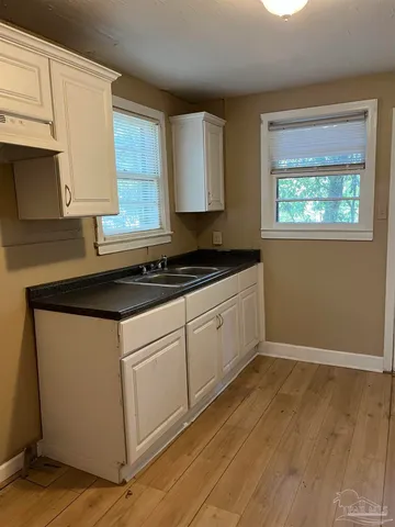 a kitchen with granite countertop white cabinets and white appliances