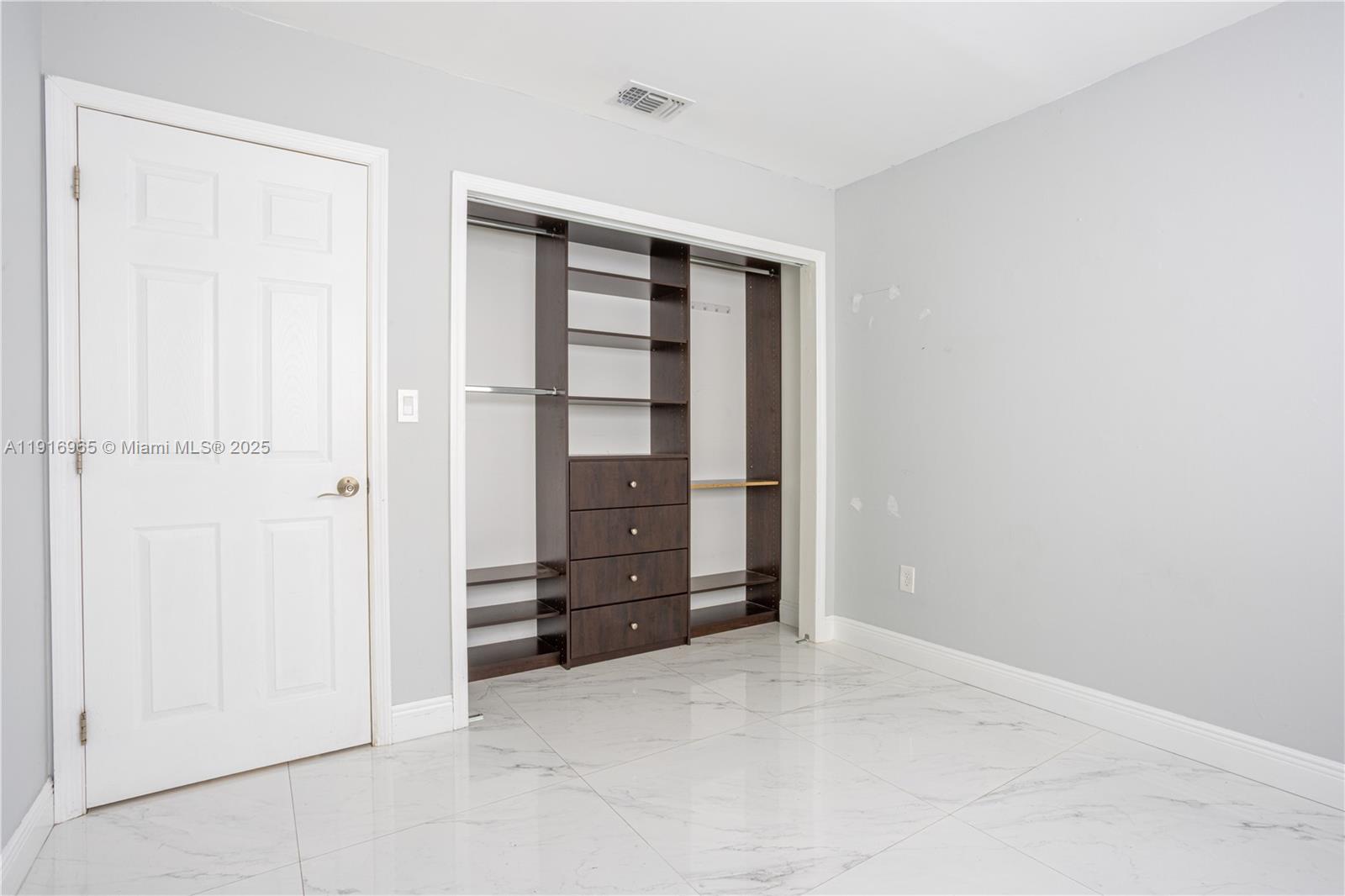 11510 Southwest 7th Street Sweetwater, FL 33174 - Photo 12 of 17 an empty room with closet and cabinet
