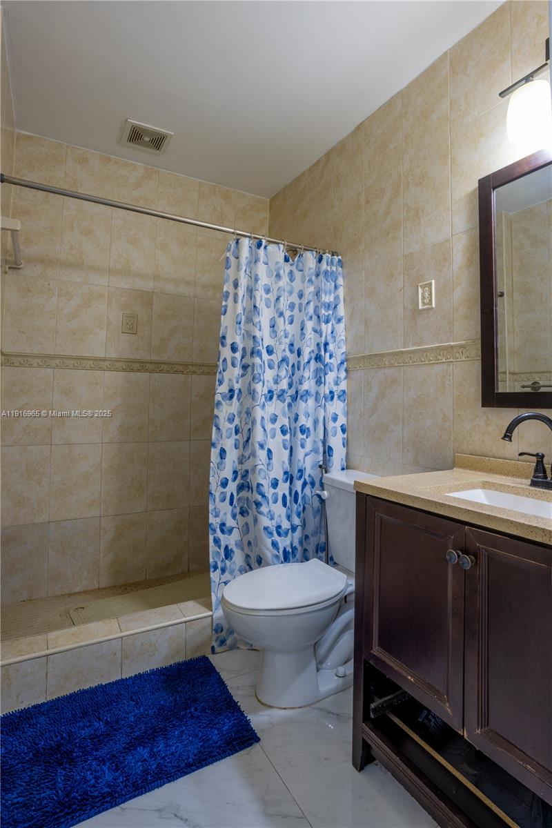 11510 Southwest 7th Street Sweetwater, FL 33174 - Photo 8 of 17 a bathroom with a sink a toilet and shower