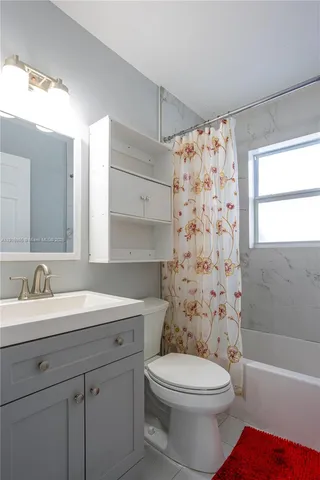 a bathroom with a sink a toilet and shower curtain