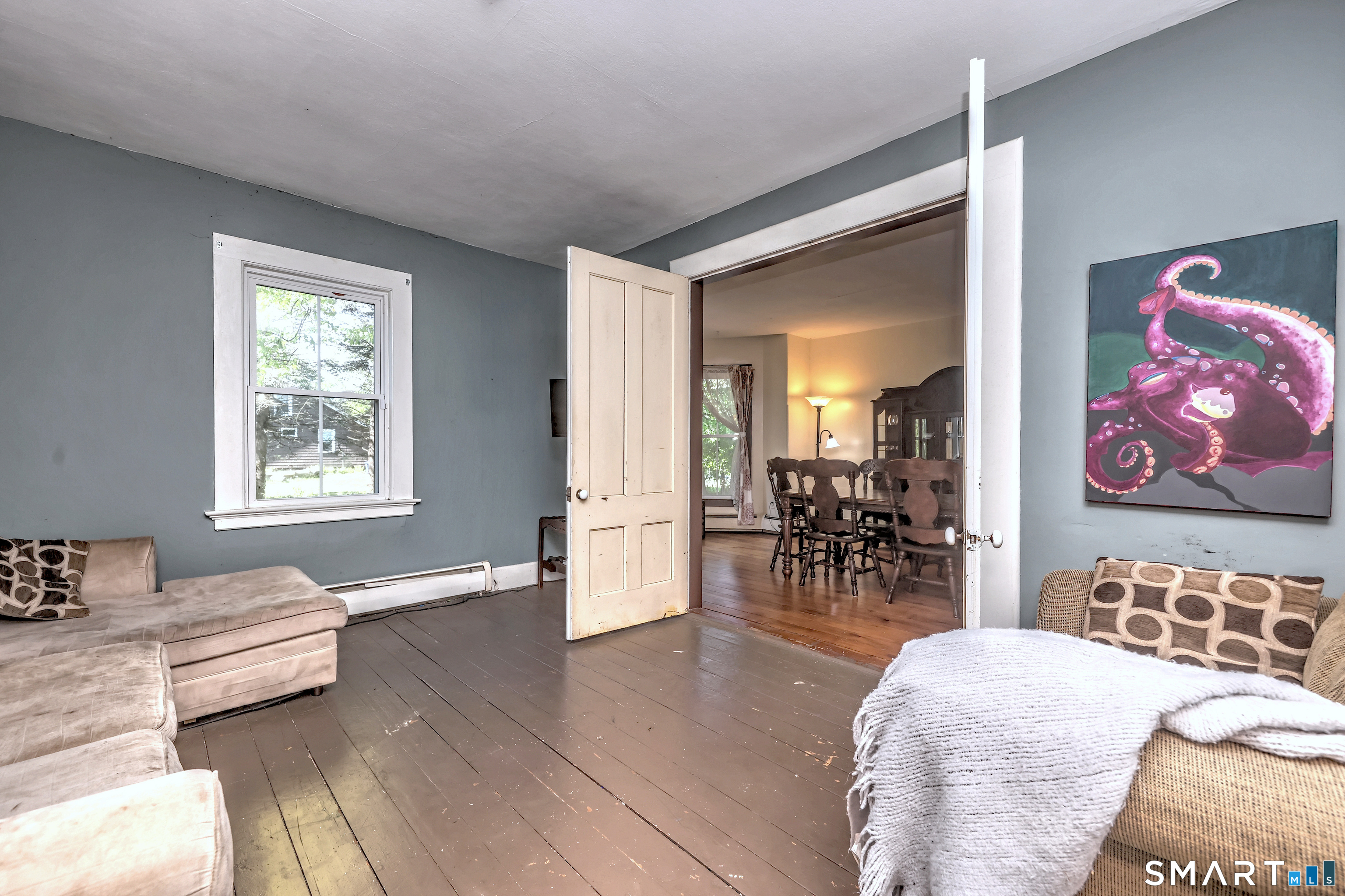 186 Jones Hill Road West Haven, CT 06516 - Photo 11 of 33 a living room with furniture and a dining table with wooden floor
