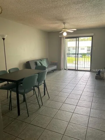 a living room with a table and chair with wooden floor