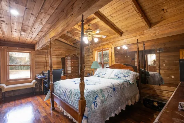 a bedroom with a bed and a dresser next to a window