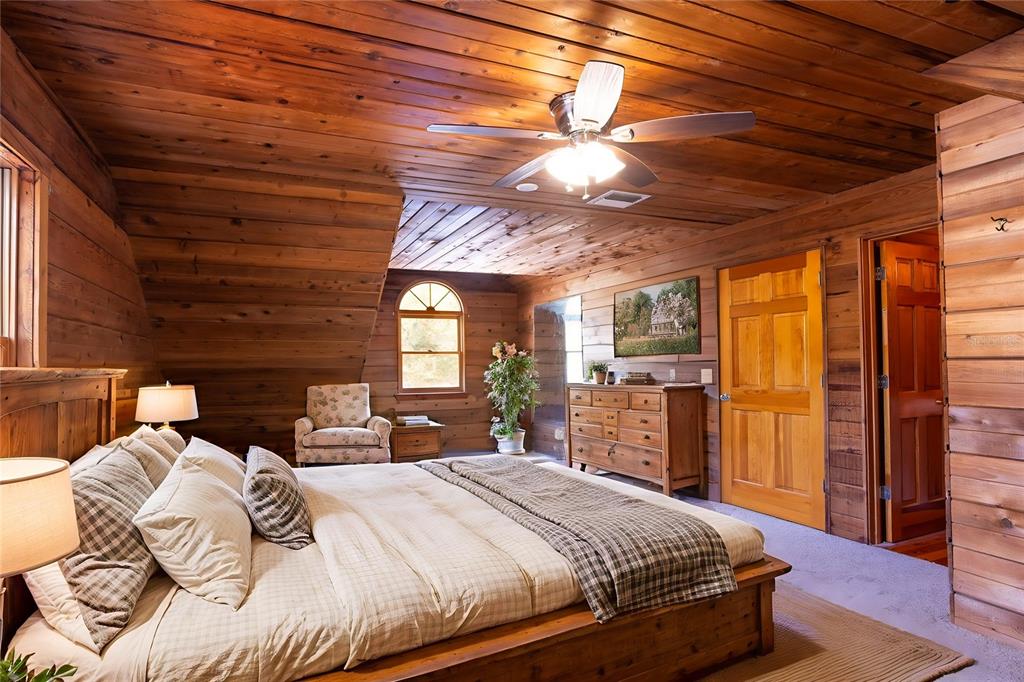 6892 Swain Road Sorrento, FL 32776 - Photo 31 of 57 a bedroom with a large bed a flat tv screen and a large window with the outer view