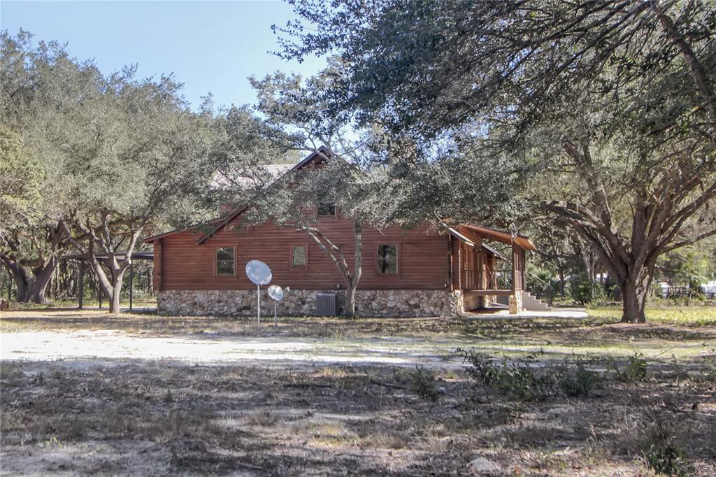6892 Swain Road Sorrento, FL 32776 - Photo 34 of 57 a backyard of a house with large trees and outdoor space