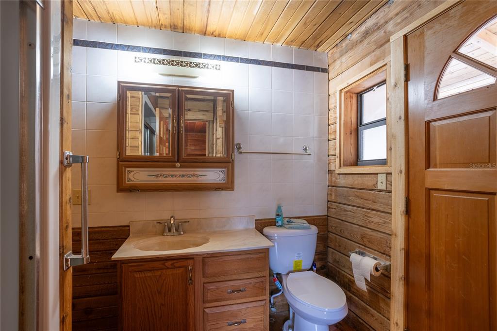 6892 Swain Road Sorrento, FL 32776 - Photo 52 of 57 a bathroom with a toilet a sink and mirror