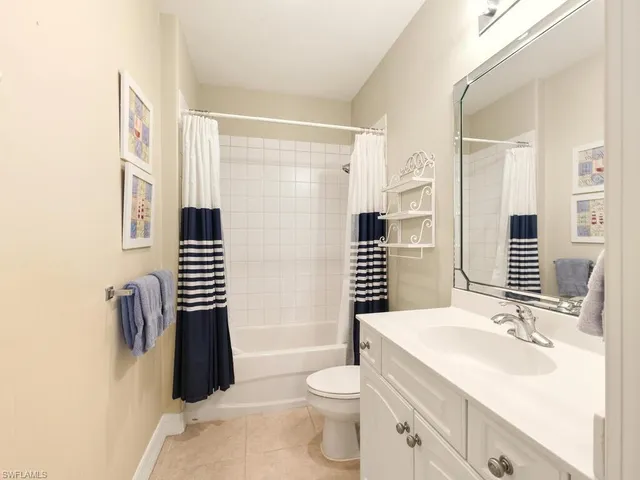 a bathroom with a sink a toilet a mirror and shower