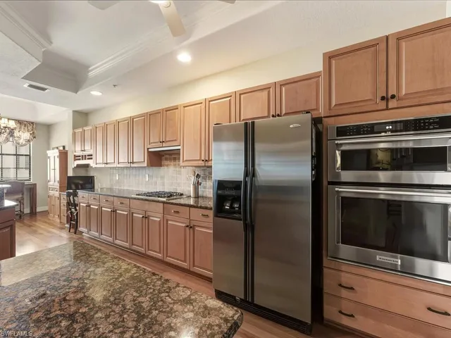 a kitchen with stainless steel appliances granite countertop a refrigerator stove and sink