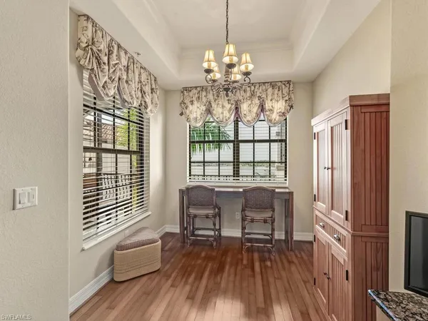 a view of a dining room with furniture a chandelier and wooden floor
