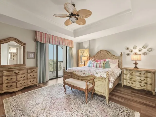 a bedroom with a bed a chandelier and dresser