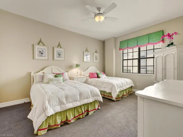 a bedroom with two beds and a window